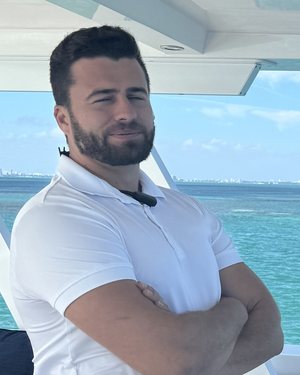 Damian Adcock at the helm of a catamaran on Biscayne Bay.